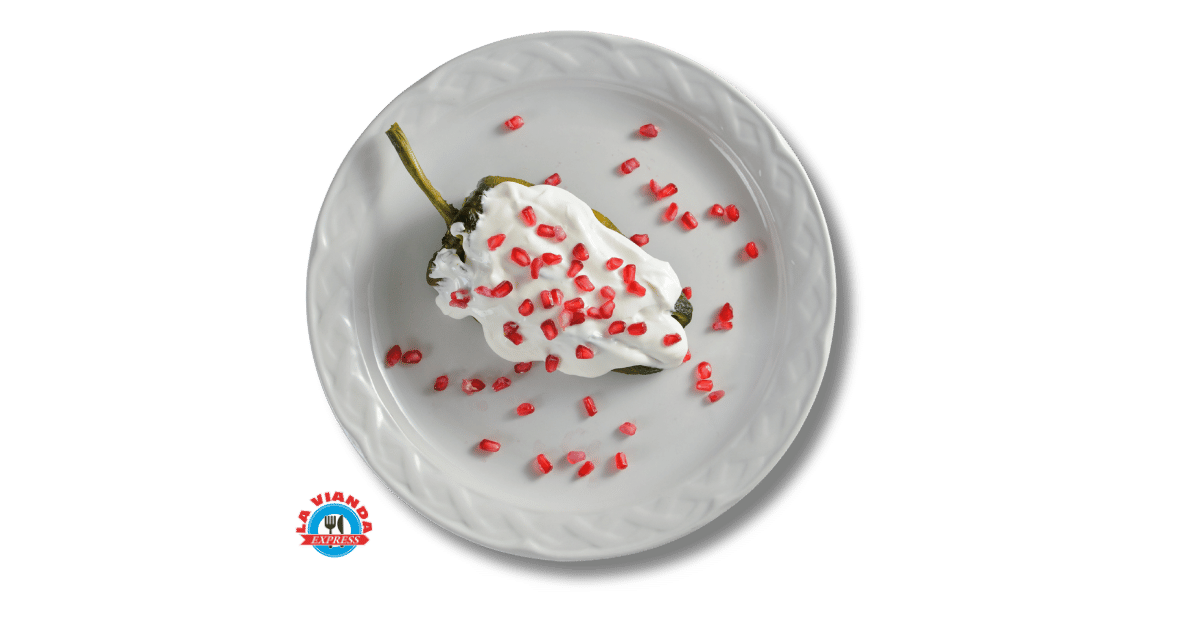 Chile en nogada con nogada blanca y granada servido en plato blanco, platillo de temporada en La Vianda Express en Morelia